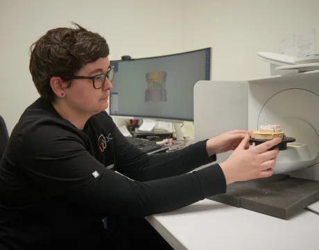 In-house dental lab technician crafting a custom implant crown